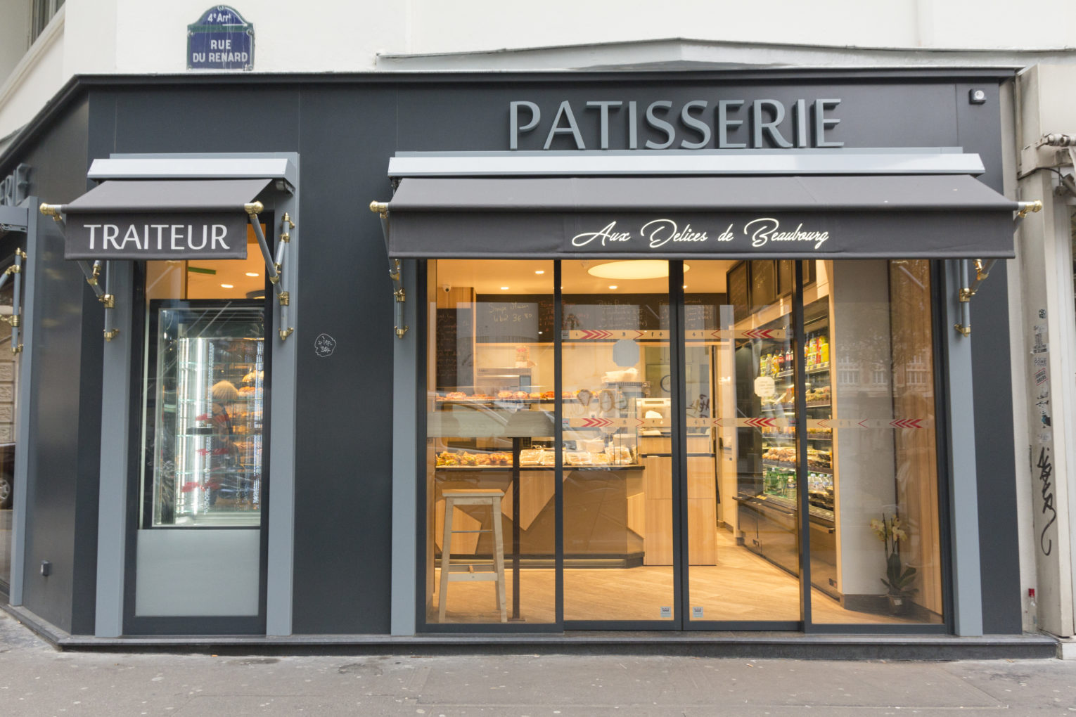 Boulangerie DÃ©lice Beaubourg faÃ§ade d'angle grise avec store banne chic dorÃ© agencement de la boutique par Pep's crÃ©ation